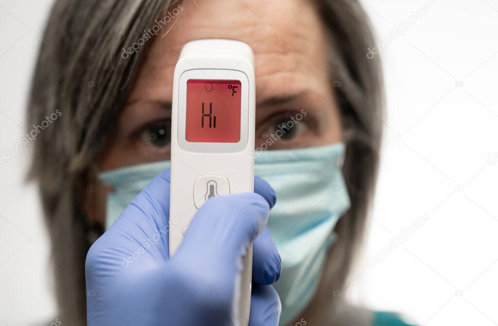 gloved hand holding a thermometer that displays HI in a red warning of a fever