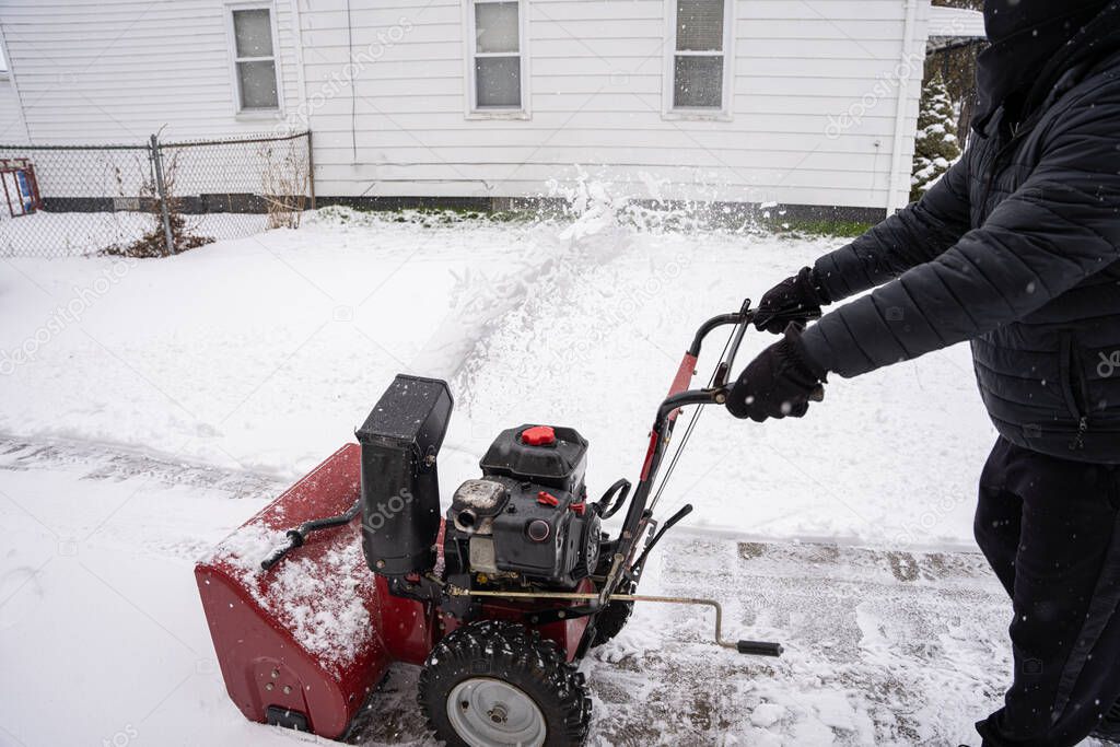snowblower is working hard to clear the fresh snow fall from your driveway after a big snow storm