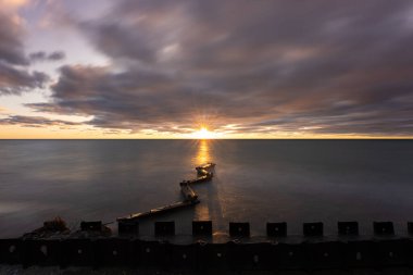 Gün batımında sakin denizlerde canlı gökyüzü gölde