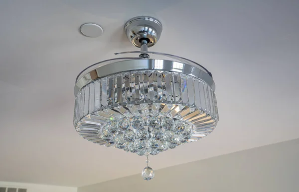 modern style chandelier is also a ceiling fan with hidden blades that expose when turned on