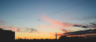 Şehir evlerinin üzerinde gün batımı.