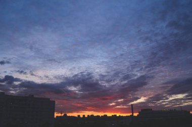 Şehir evlerinin üzerinde gün batımı.