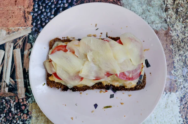 Rozskenyeres szendvics fehér gyömbérrel, paradicsommal, olvadt sajttal, bazsalikommal és csirkével rózsaszín tálcán — Stock Fotó