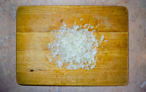 Fein geschnittene Zwiebeln auf einem Holzbrett zum Schneiden — Stockfoto