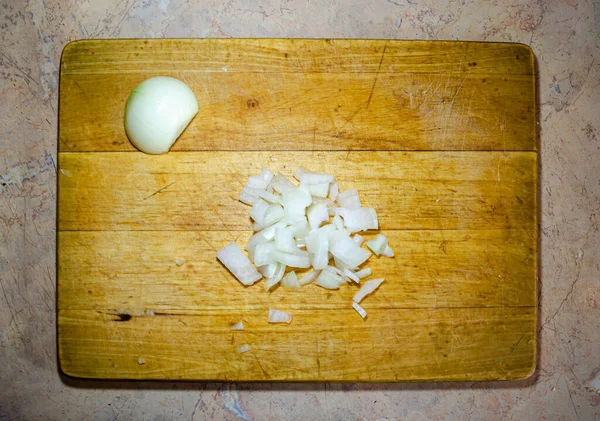 Fein geschnittene Zwiebeln auf einem Holzbrett zum Schneiden — Stockfoto