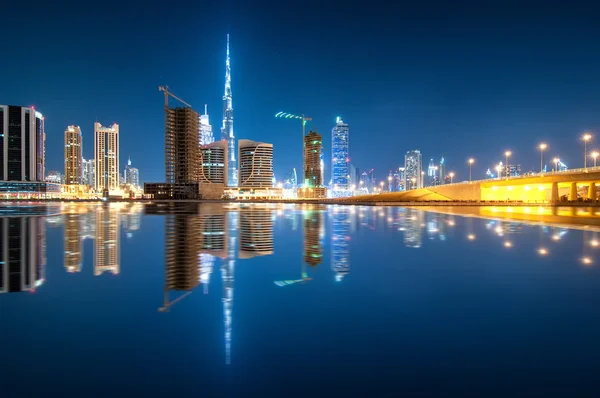 Fascinating reflection of tallest skyscrapers in Business Bay district during calm night. Downtown summer night. Construction built at night time. Dubai, United Arab Emirates. — Stock Photo, Image