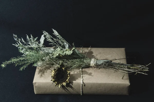 Kraft kağıt hediye kutusu, kurumuş ayçiçeği süsüyle hediye.