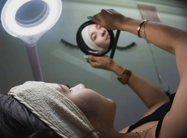 Mujer Joven Mira Espejo Después Recibir Tratamiento Facial — Foto de Stock