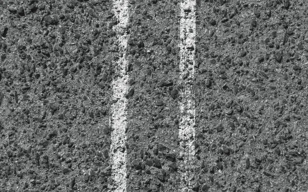 White stripes on the asphalt road. Top view. Background texture
