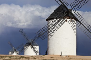 Windmills and dark, cloudy sky, Campo de Criptana, Spain clipart