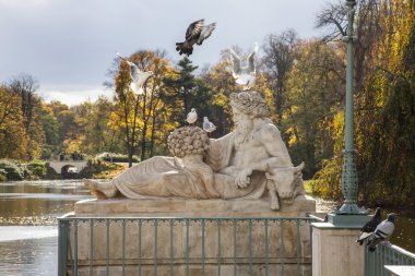 Kuşlar ve heykel, sonbahar Park, Varşova, Polonya