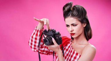 Esmer, retro tarzında güzel bir kadın eski bir kamera kurmaya çalışıyor.