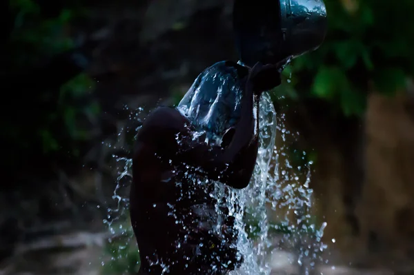 Čistá voda osvěžuje unavené tělo černý muž během večerní očistu (Bomassa, Konžská republika) — Stock fotografie