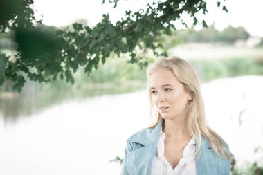 Nehrin kıyısındaki ağacın altında düşünceli bir kadın. Yüksek kalite fotoğraf