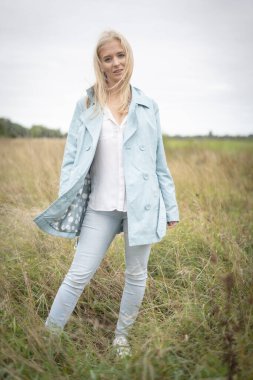 Bir tarlada uzun otların arasında duran genç bir kadın. Yüksek kalite fotoğraf