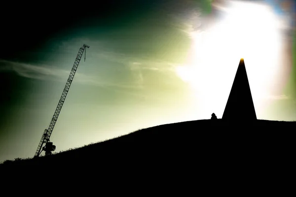 Sunset Silhouette Of Person And Statue On A Hill