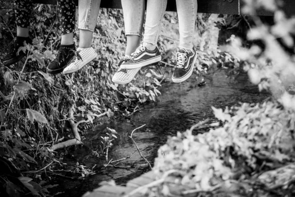 Drei Beinpaare Baumeln Von Einer Brücke Über Einen Kleinen Fluss — Stockfoto