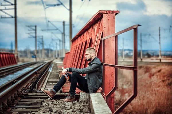 鉄道の上に座ってのひげを持つ男 — ストック写真