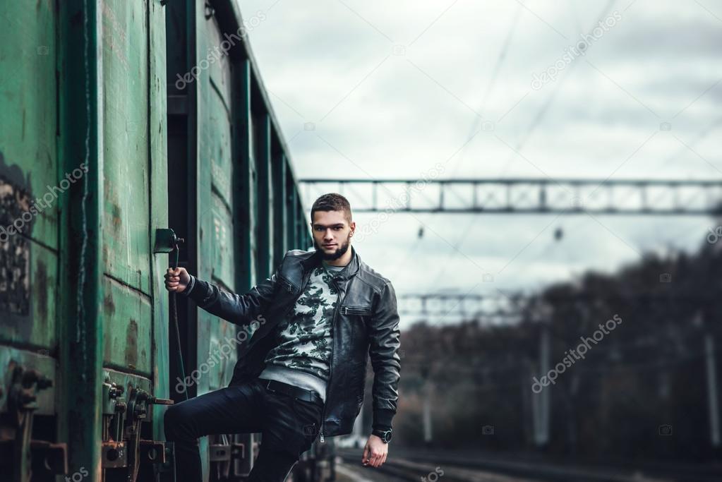 Man with beard walking on the railway