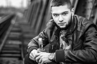 Demiryolu üzerinde oturmuş sakallı