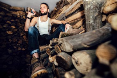 Adam yakacak odun stok yakınındaki bir balta ile