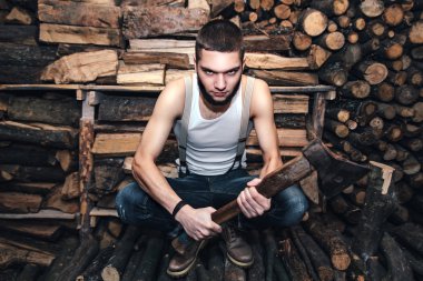 Adam yakacak odun stok yakınındaki bir balta ile