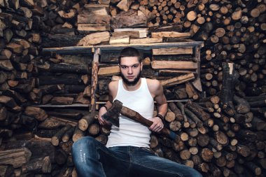 Adam yakacak odun stok yakınındaki bir balta ile