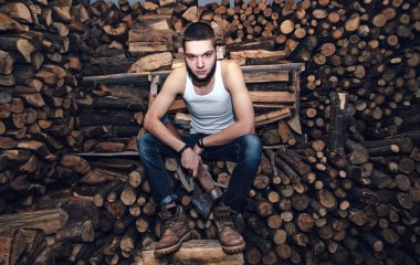 Adam yakacak odun stok yakınındaki bir balta ile