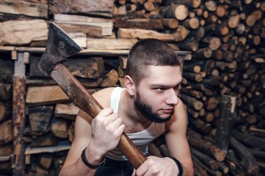 Adam yakacak odun stok yakınındaki bir balta ile