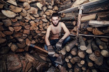 Adam yakacak odun stok yakınındaki bir balta ile