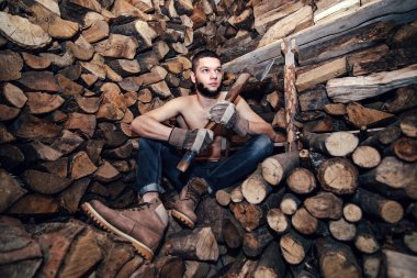 Adam yakacak odun stok yakınındaki bir balta ile