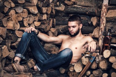 Adam yakacak odun stok yakınındaki bir balta ile