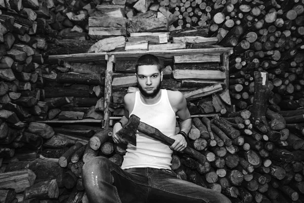 Homme avec une hache près du bois de chauffage — Photo