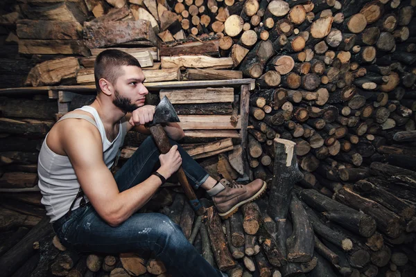 Adam yakacak odun stok yakınındaki bir balta ile