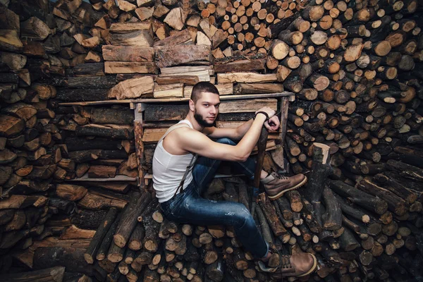 Muž se sekerou poblíž dřevo skladem — Stock fotografie