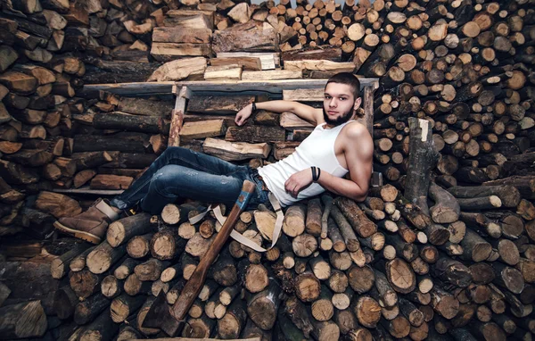 Seorang pria dengan kapak dekat stok kayu bakar — Stok Foto