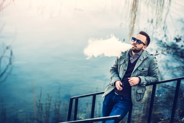 Man with beard vaping outdoor — Stock Photo, Image