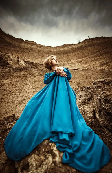 Vrouw in lange blauwe jurk — Stockfoto