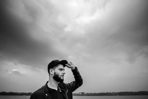Человек с бородой на открытом воздухе с озером позади — стоковое фото