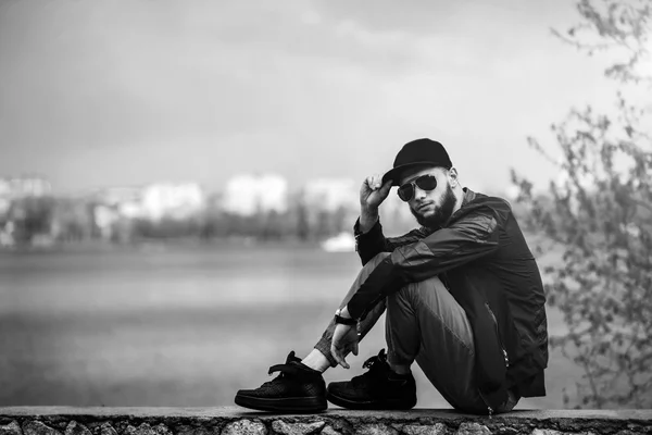 Homem com barba ao ar livre com lago atrás — Fotografia de Stock