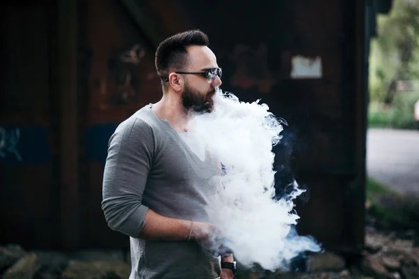 Homem de óculos de sol vaping ao ar livre — Fotografia de Stock