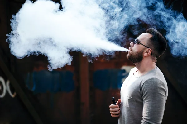 Mann mit Sonnenbrille dampft draußen — Stockfoto