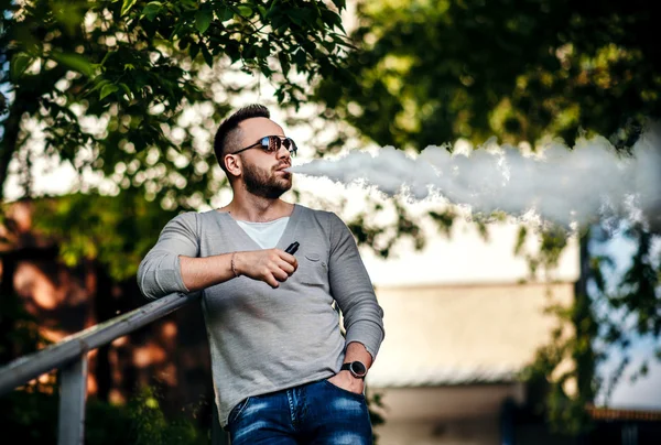 Uomo in occhiali da sole vaporizzare all'aperto — Foto Stock