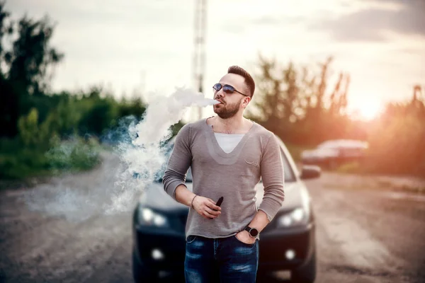 Man in sunglasses vaping outdoor — Stock Photo, Image