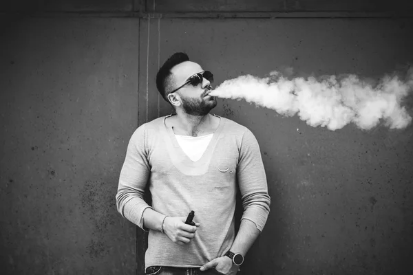 Homem de óculos de sol vaping ao ar livre — Fotografia de Stock