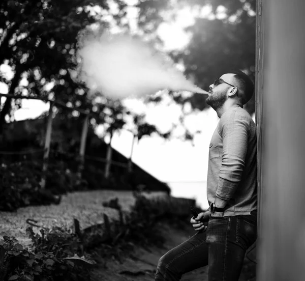 Homem de óculos de sol vaping ao ar livre — Fotografia de Stock