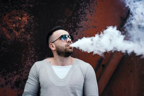 Homem de óculos de sol vaping ao ar livre — Fotografia de Stock