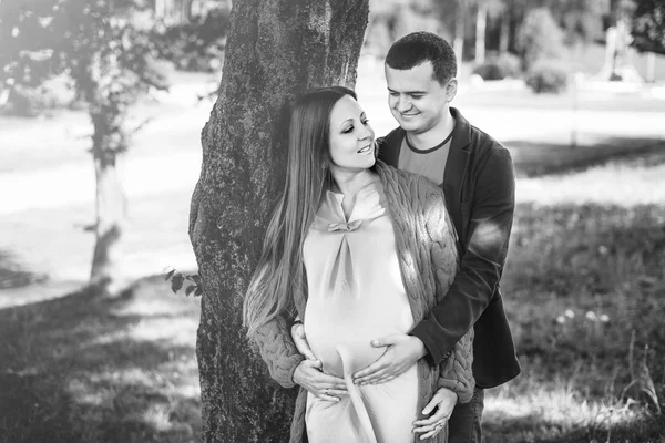 Těhotná žena s manželem v parku — Stock fotografie