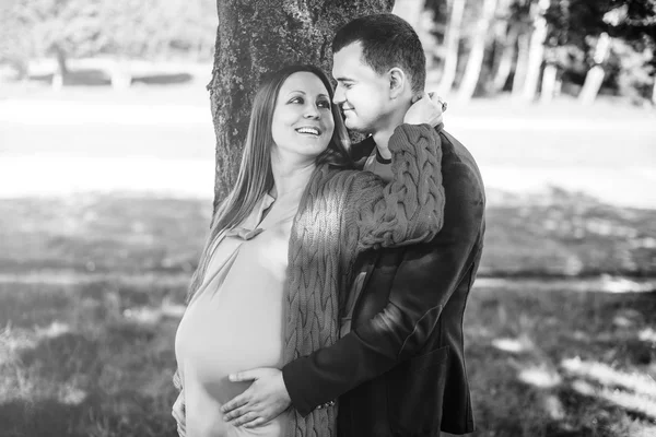 Беременная женщина с мужем в парке — стоковое фото