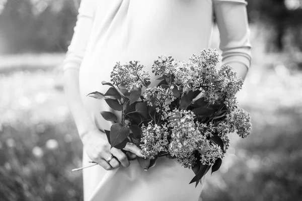 Preagnant kvinna i parken med lila blommor — Stockfoto